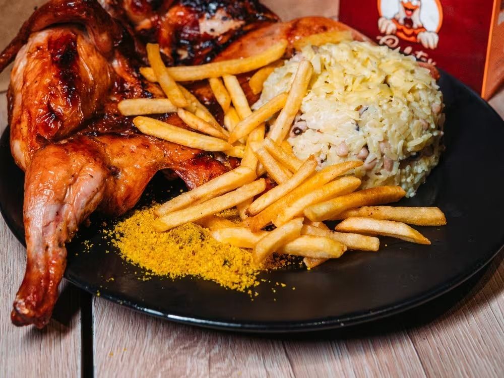 Prato de galeto assado na brasa com baião de dois, batata frita e farofa — Fortaleza
